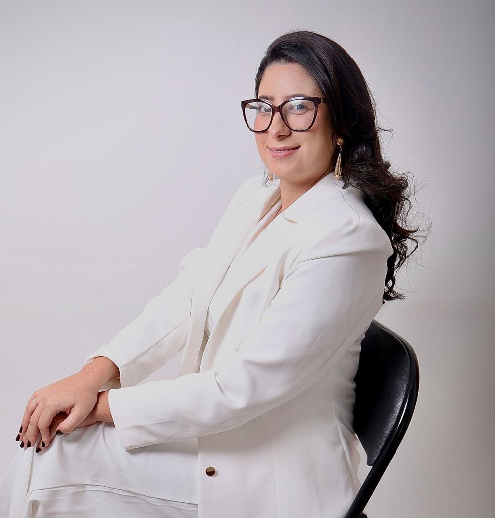 Vanessa Costa, de óculos e blazer branco